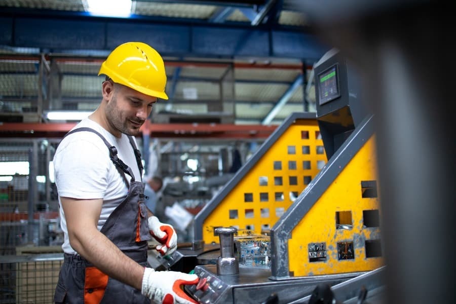 homem vestido de EPIs apertando botão de emergencia de maquina industrial homem vestido de EPIs apertando botão de emergencia de maquina industrial